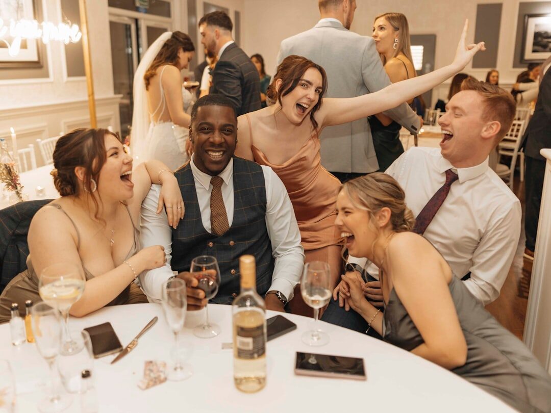 Group of colleagues holding drinks and laughing at an evening event