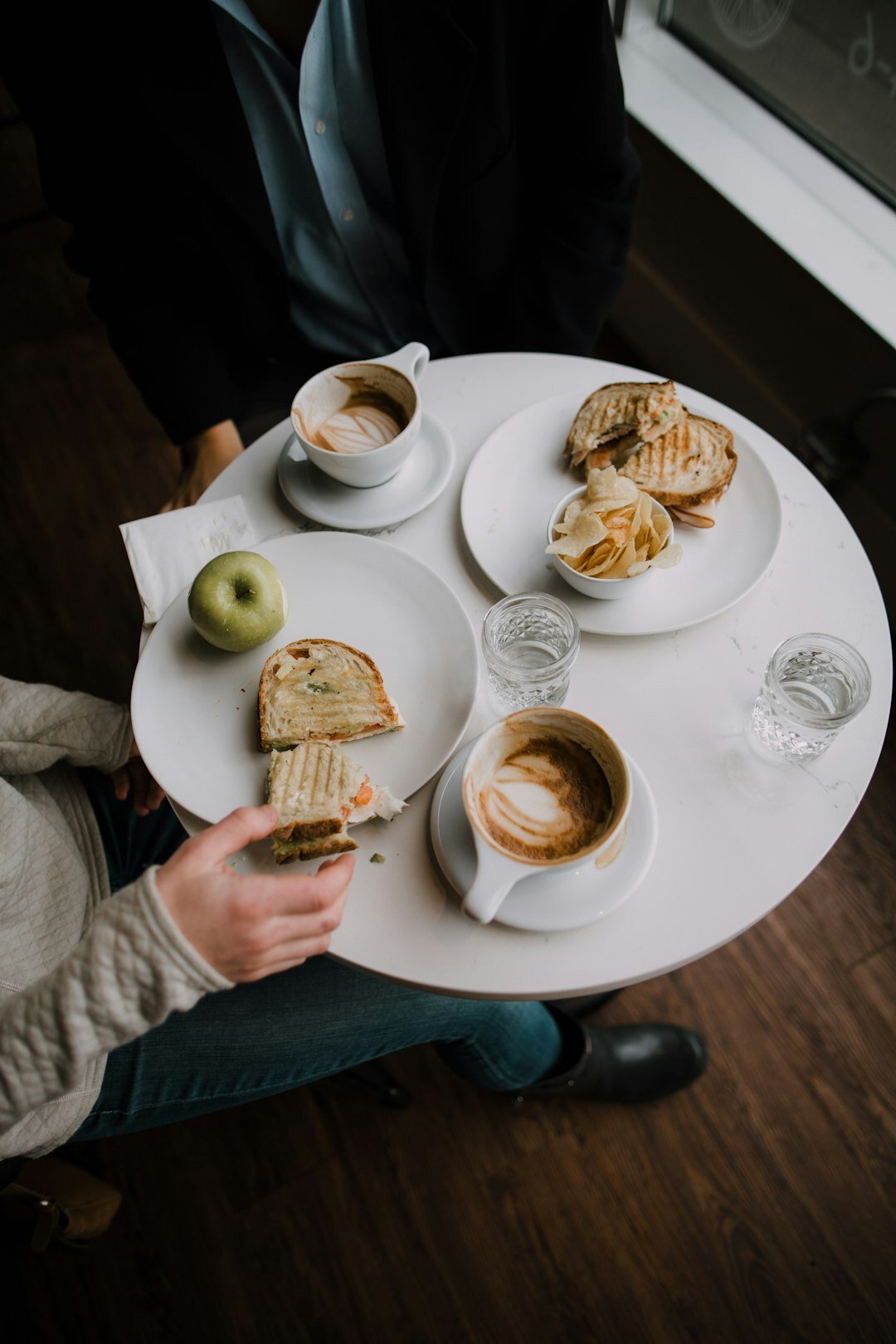 Two professionals having coffee and talking during a breakfast meeting