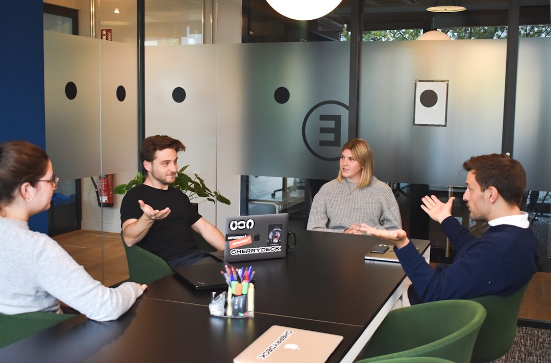 Small team of colleagues discussing around a table in a bright office